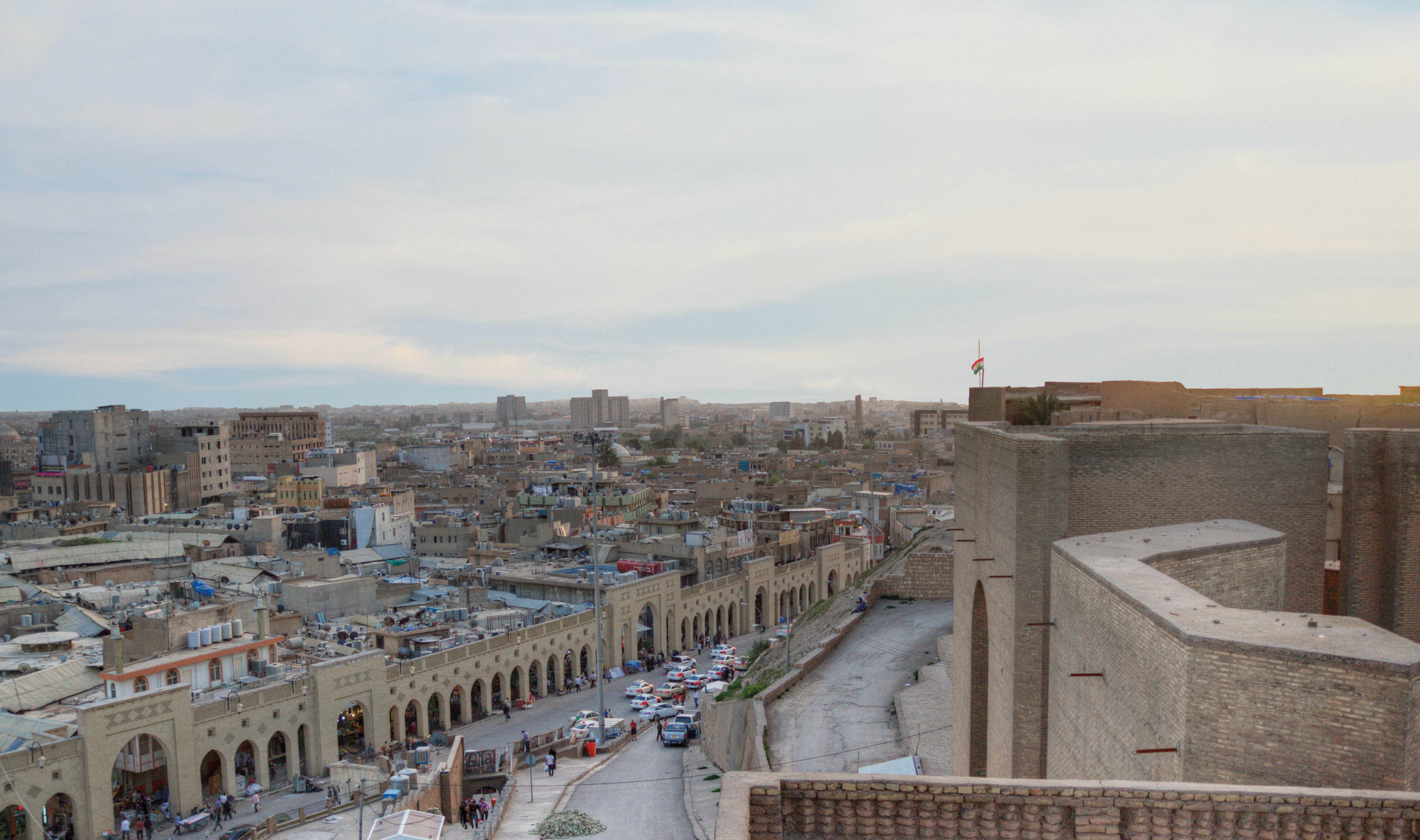 View of Erbil city with people at citadel's southern gate in sunset, Kurdistan, northern Iraq.