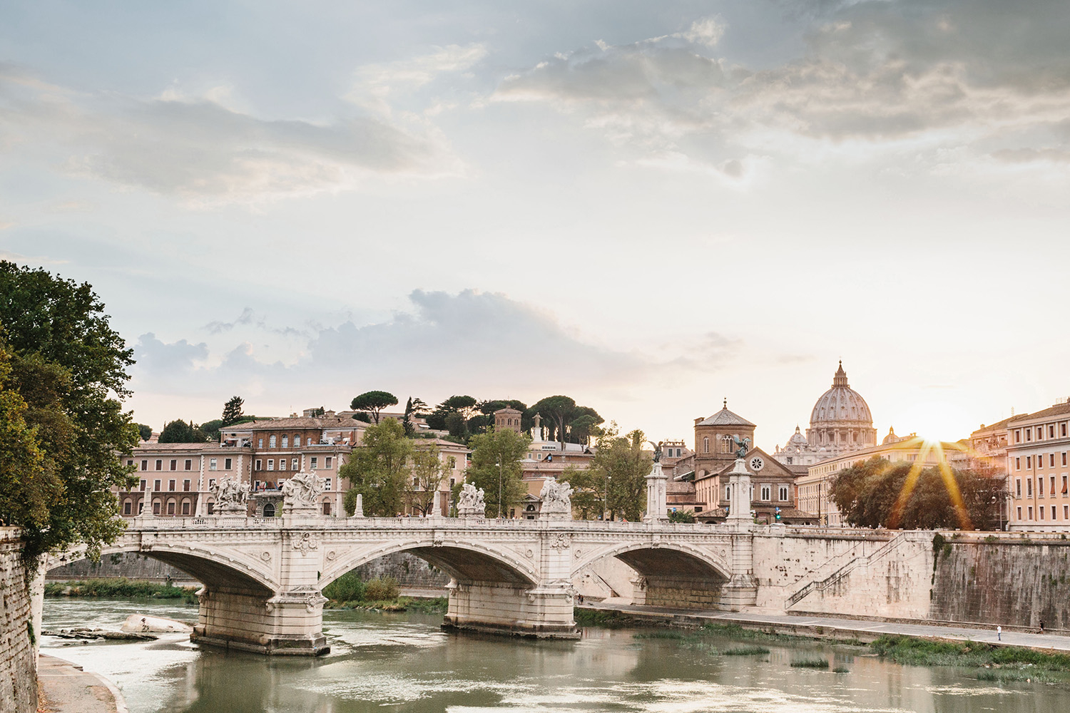 One of the most romantic views of Rome is standing by the River Tiber across to Vatican City and St Peters Cathedral beyond. The rooftops, stone bridges, the river and a beautiful orange sunset make for a most magical view.