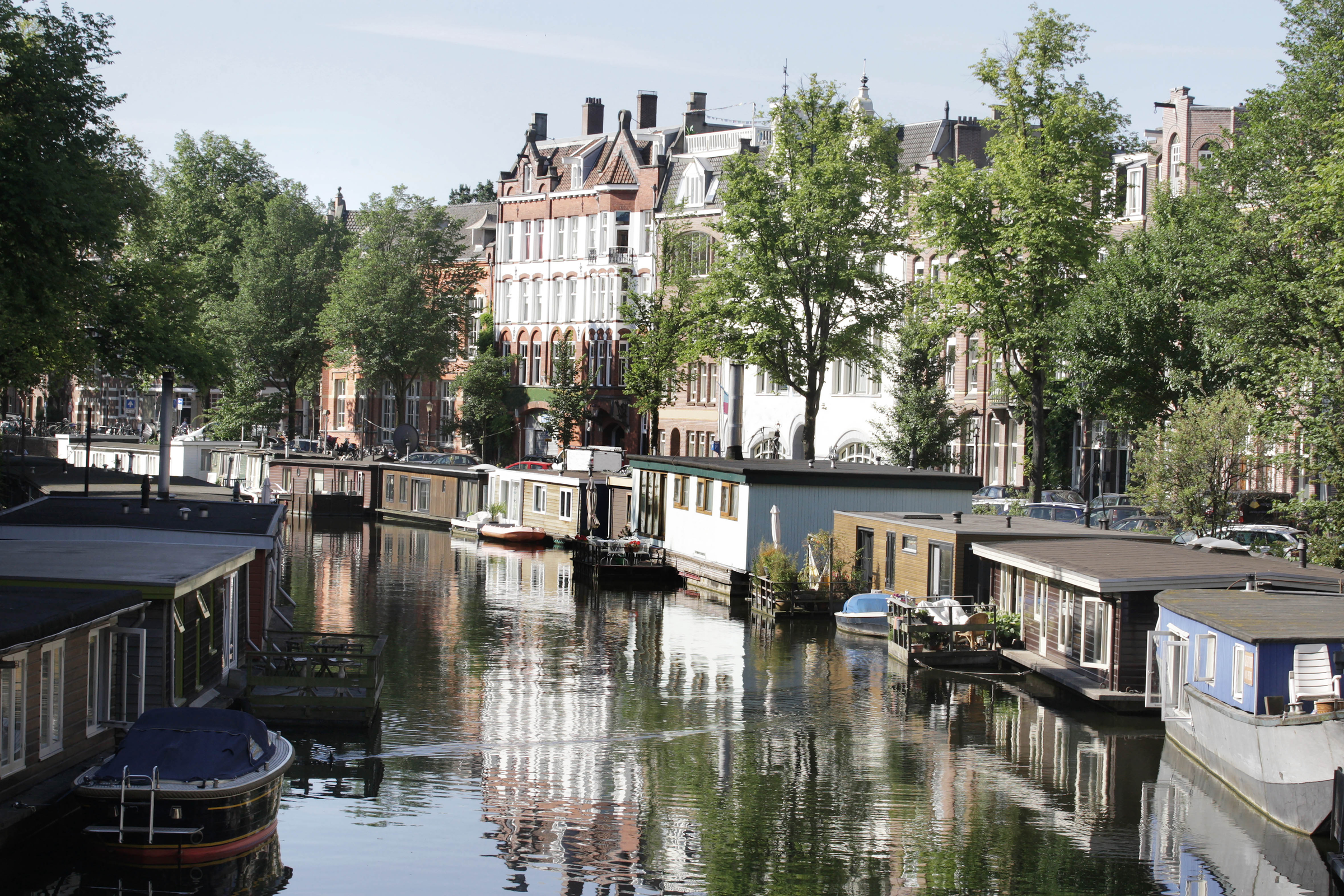 AMSTERDAM,NETHERLANDS - JULY 16: Houseboats on the canal and traditional Dutch bungalos at Da Costakade street during Summer in Amsterdam,Netherlands.