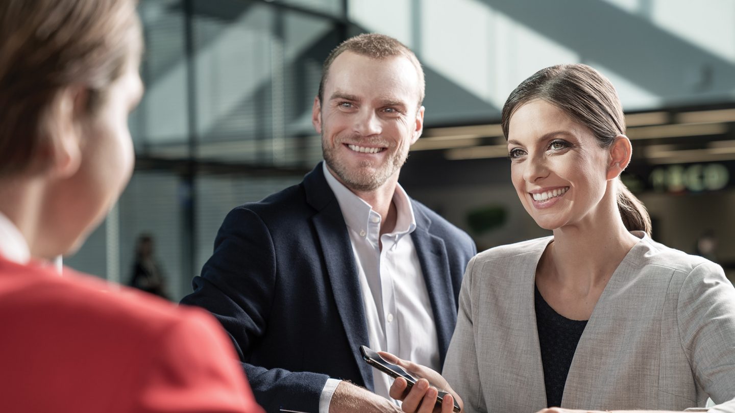 Two passengers talking to an Austrian employee