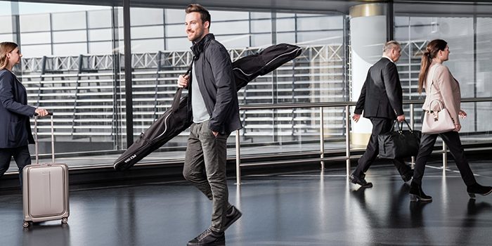 A young passenger carrying his sports baggage at the airport