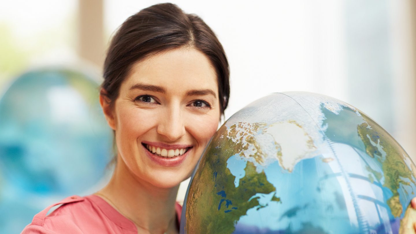 A young woman with a globe in her hand