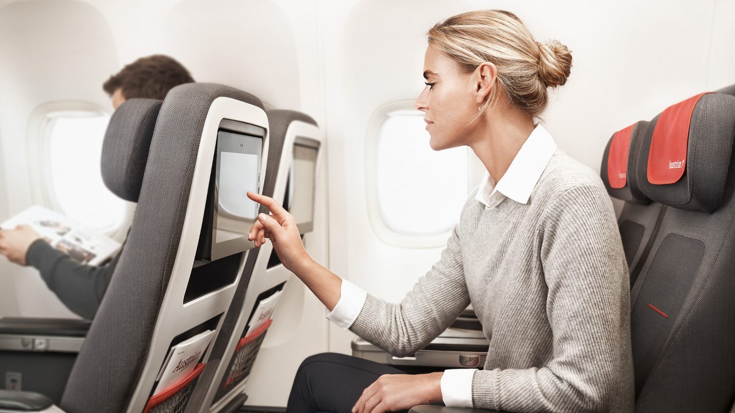 A young woman uses the inflight entertainment offer