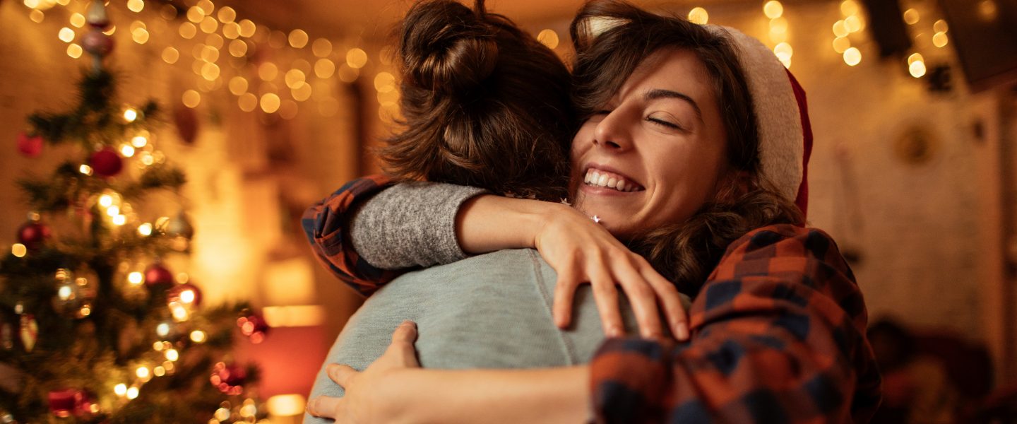 Boy and girl hugging by the Christmas tree